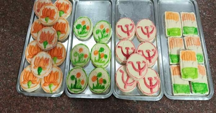 in the showcase of the sweet shop you can see the sandesh decorated with the symbols of all he parties